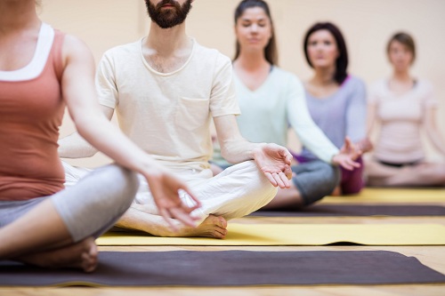 Group of people sitting in lotus position